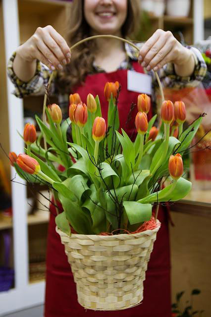 a basketful of tulips handed over by a florist